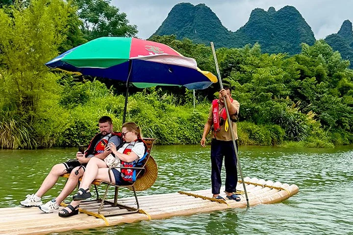 Travelers enjoying bamboo rafting near Yangshuo